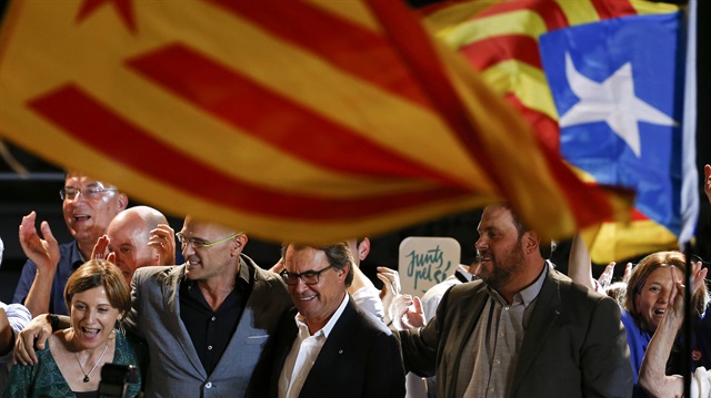 Catalan President Artur Mas (C) stands with ERC's Oriol Junqueras (R), Raul Romeva (2nd L) and other politicians as they address Junts Pel Si (Together For Yes) supporters after polls closed in a regional parliamentary election in Barcelona, Spain, September 27, 2015. Separatists have won a clear majority of seats in Catalonia's parliament, an exit poll showed on Sunday, in an election that could set the region on a collision course with Spain's central government over independence. 
