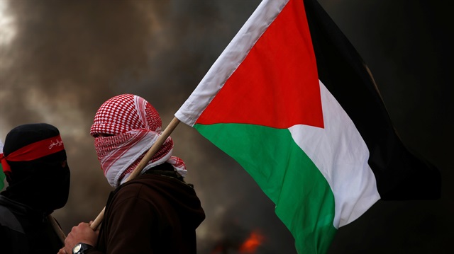A demonstrator holds a Palestinian flag during a protest against what organizers said was a visit by a group of Bahraini people to Israel, in the northern Gaza Strip 

