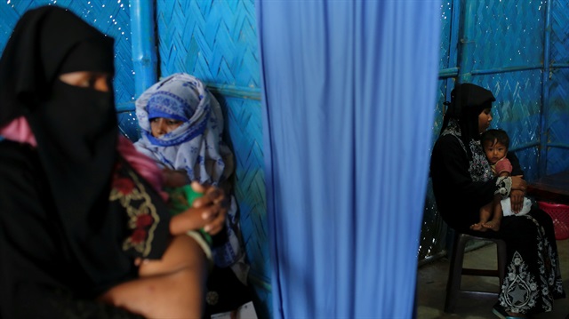 Rohingya refugees wait for their babies to be examined by doctors