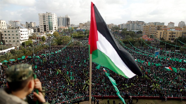 A Palestinian flag is seen as Hamas supporters take part in a rally