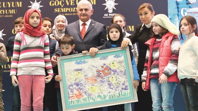 Göç ve Uyum Sempozyumu’nun açılışına katılan Başbakan Binali Yıldırım, kendisine resim hediye eden Suriyeli çocuklarla fotoğraf çektirdi.