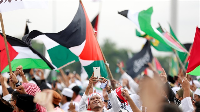 A protester takes a picture with his handphone during a rally to condemn U.S. President Donald Trumps's decision to recognise Jerusalem as Israel's capital, at Monas, the national monument, in Jakarta, Indonesia