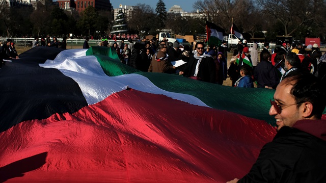Protesters unfurl an oversized Palestinian flag