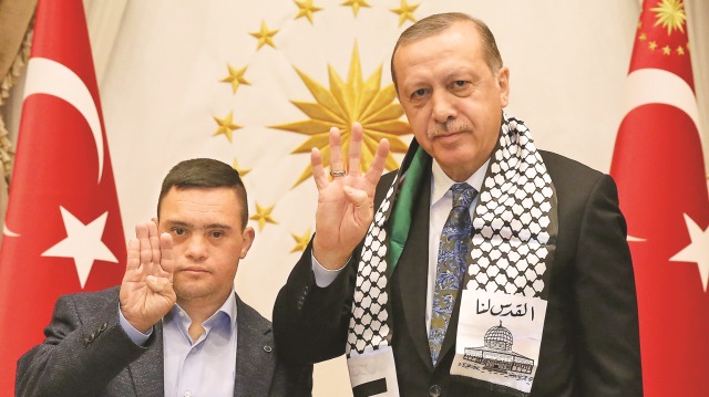 Erdoğan, İsrail askerlerinin gözaltına alıp tepkiler üzerine serbest bıraktıkları down sendromlu Muhammed et-Tavil ile Rabia işareti yaptı.