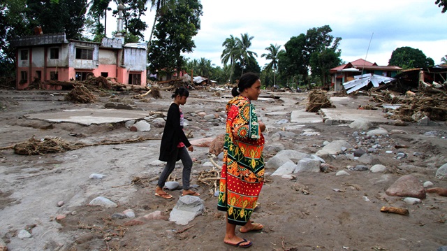 Residents are seen near a mosque in a village devastated by flash floods in Salvador, Lanao del Norte in southern Philippines, December 24, 2017.