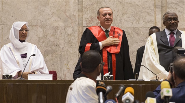 President of Turkey Recep Tayyip Erdogan greets after receiving the title of honorary PhD from the University of Khartoum in Khartoum, Sudan