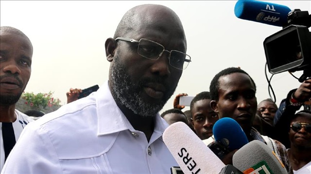 Football icon and candidate for the president election for Coalition for Democratic Change (CDC), George Weah (2nd L) speaks to journalists after casting his ballot for second round of presidential elections