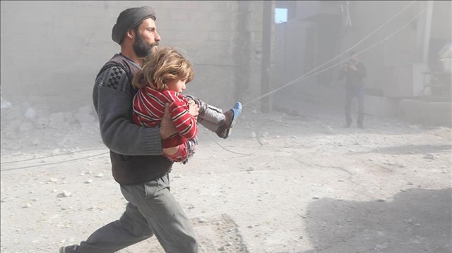 A Syrian man runs with his daughter following the Assad regime's air strikes over residential areas in the de-escalation zone in the Eastern Ghouta region in Damascus, Syria