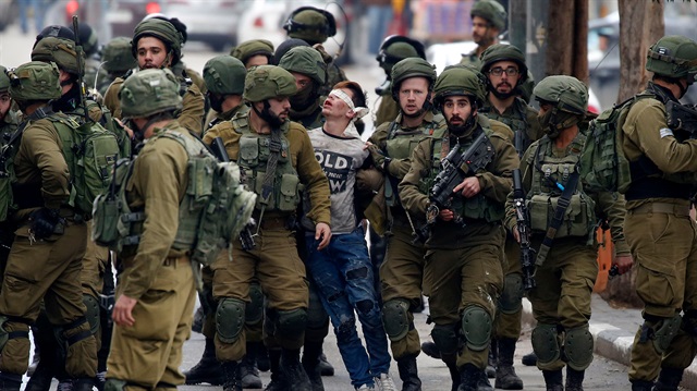 Cüneydi'nin onlarca İsrail askeri tarafından gözleri bağlanarak gözaltına alındığı anın fotoğrafı direnişin sembolü oldu.