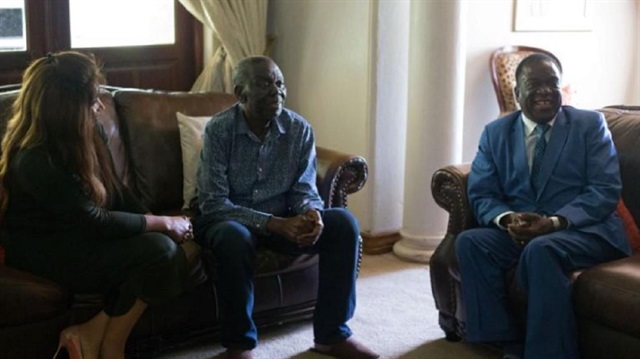 Zimbabwean President Emmerson Mnangagwa (R) chats during his visit to opposition leader Morgan Tsvangirai (C) and his wife, Elizabeth, at his house in Harare, Zimbabwe