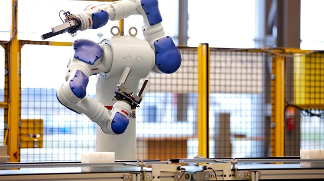 ABD'de bir tesiste üretim bandında insan yerine çalışan robot. 