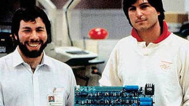 Steve Wozniak ve Steve Jobs bir anakartı tutuyor.