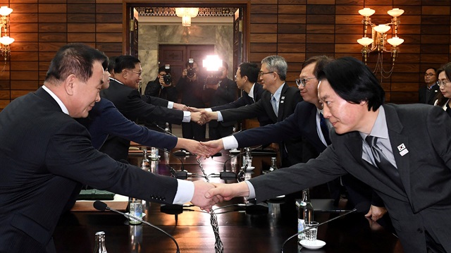 South and North Korean delegation shake hands during their meeting at Tongilgak in Panmunjom