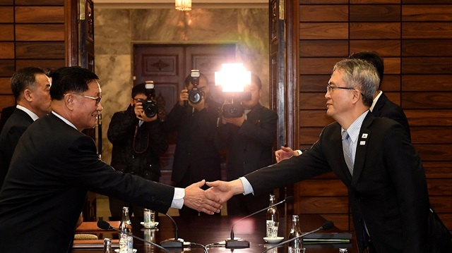 Kwon Hyok Bong, director of the Arts and Performance Bureau in North Korea's Culture Ministry, shakes hands with Lee Woo-sung, head of the culture and arts policy office at the culture ministry, during their meeting at Tongilgak in Panmunjom