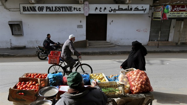 Palestinians pass by a closed bank during a commercial strike in protest against the economic situation, in Rafah in the southern Gaza Strip January 22, 2018. REUTERS/Ibraheem Abu Mustafa