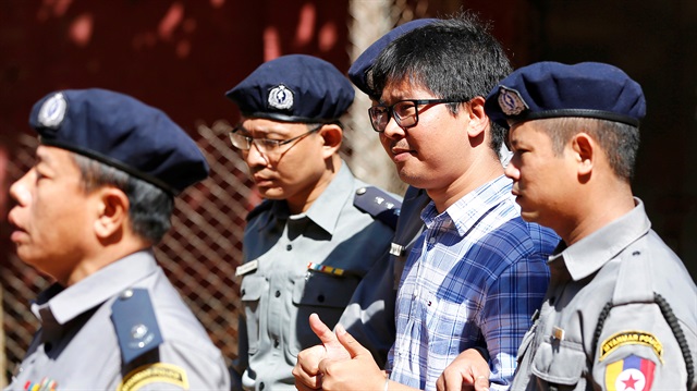 Detained Reuters journalist Wa Lone is escorted by police for a court hearing in Yangon