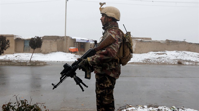 An Afghan security force member stands guard 