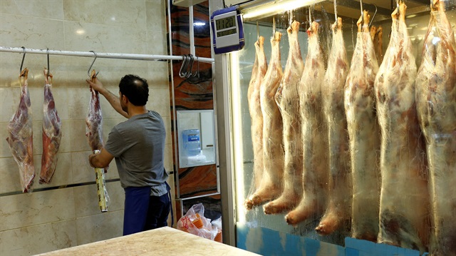 A butcher holds pieces of beef at a meat shop in Istanbul, Turkey