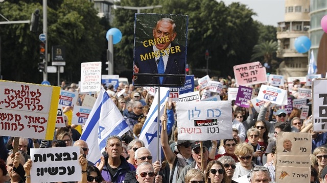 Polis tarafından rüşvet almakla suçlanan Netanyahu göstericiler pankartlarla protesto etti