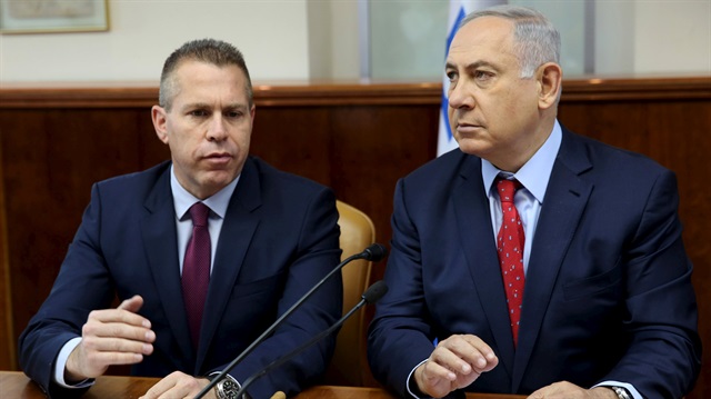 Israeli Prime Minister Benjamin Netanyahu (R) sits next to Israeli Public security Minister Gilad Erdan during the weekly cabinet meeting in Jerusalem April 10, 2016. 
