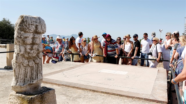 Tourists listen to their guide during their visit to the archaeological site of Carthage