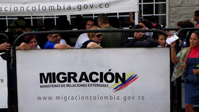 Venezuelans stand in line at the border between Venezuela and Colombia, in Paraguachon