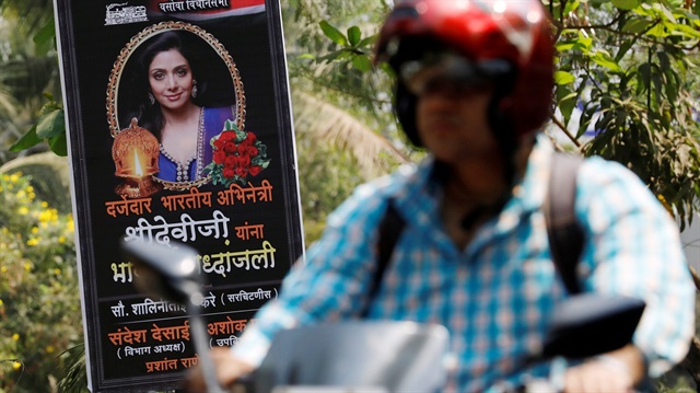 A man rides past a poster of Bollywood actor Sridevi outside her house in Mumbai, India, February 27, 2018. The poster reads "To a quality Indian actress, Sridevi, we pay a heartfelt tribute."
