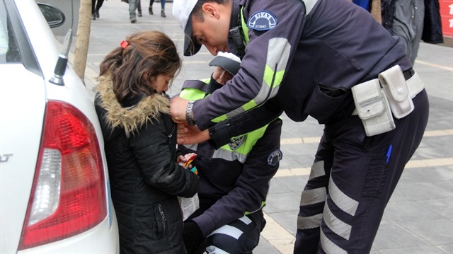 Kağıt mendil satarken yetişkinlerin sorularından sıkılıp ağlamaya başlayan kız çocuğunu polis sakinleştirdi