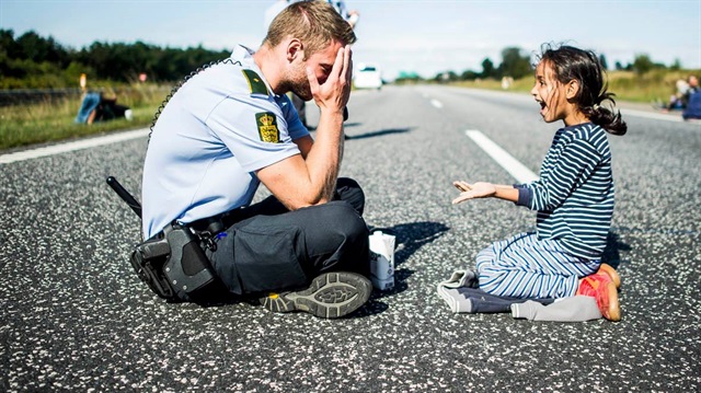 Danimarkalı polis, Iraklı mülteci kız ile oyun oynayarak poz vermişti. (9 Eylül 2015/Reuters)
