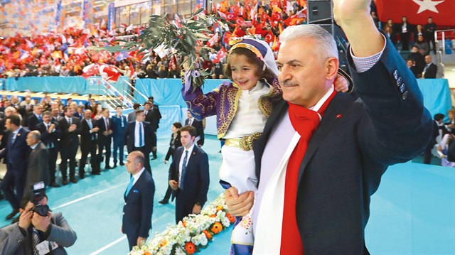 Başbakan Yıldırım, salona girişinde elinde zeytin dalı olan yöresel kıyafetli bir çocukla katılımcıları selamladı.