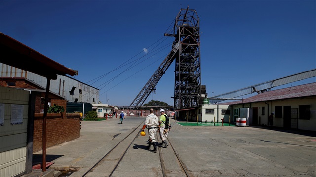 File Photo: Mine workers walk past the pit head at Sibanye Gold's Masimthembe shaft in Westonaria