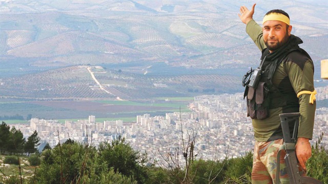 Halidiye köyünün alınmasıyla birlikte Afrin ilçesi artık çıplak gözle bile izlenebiliyor. Bir ÖSO savaşçısı, ilçe doğusundaki dağda böyle poz verdi.