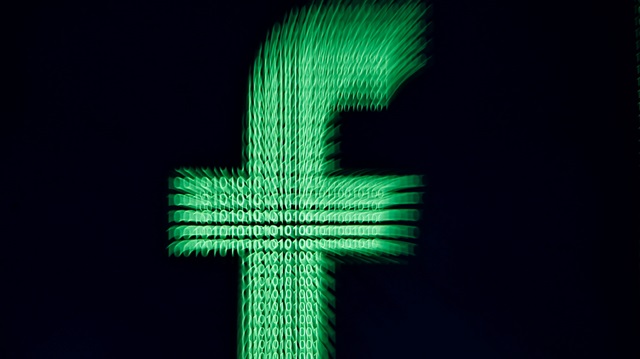 A 3D-printed Facebook logo is displayed in front of binary digits in this illustration taken, March 18, 2018.
