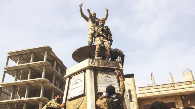 Terör örgütünün öldürülen PKK’lılar için diktiği anıtın üzerine çıkan ÖSO askerleri böyle poz verdi.