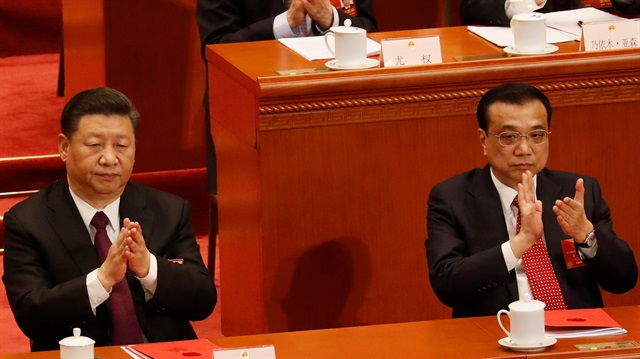 Chinese President Xi Jinping and Chinese Premier Li Keqiang clap their hands during the closing session of the NPC at the Great Hall of the People in Beijing