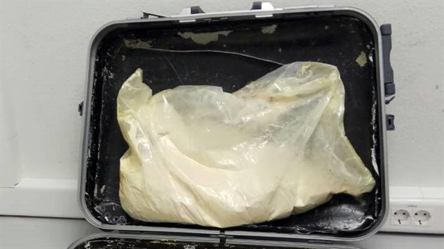 A photo provided by the Greek police shows 11 kilos of heroin hidden in the suitcase 
