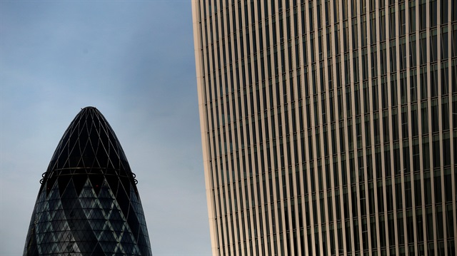 The Swiss Re building, known as the Gherkin (L), is seen in London, Britain, February 28, 2013.