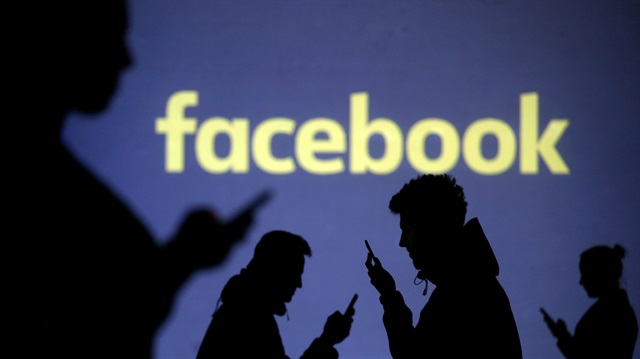 File Photo: Silhouettes of mobile users are seen next to a screen projection of Facebook logo in this picture illustration taken March 28, 2018.