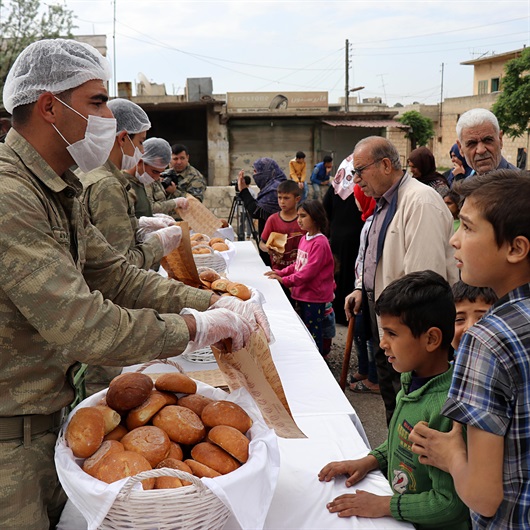 Turkish soldiers distribute bread in Syria's Jinderes