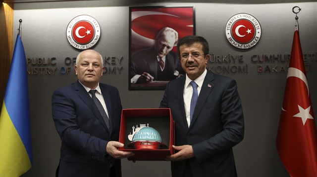 Turkish Economy Minister Nihat Zeybekci (R) welcomes Ukraine's First Vice Prime Minister and Economy Minister Stepan Kubiv (L) ahead of their meeting in Ankara, Turkey on April 12, 2018.