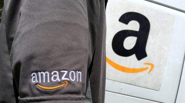 FILE PHOTO: An Amazon.com Inc driver stands next to an Amazon delivery truck in Los Angeles, California, U.S., May 21, 2016.