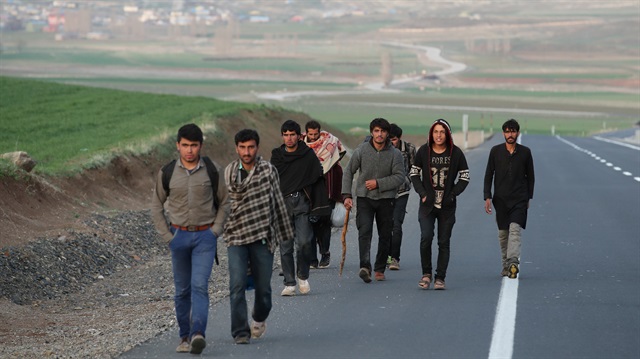 A group of Afghan migrants walk along a main road after crossing the Turkey-Iran border near Doğubayazit, Ağri province, eastern Turkey, April 11, 2018. 