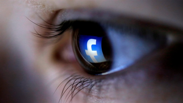 A picture illustration shows a Facebook logo reflected in a person's eye