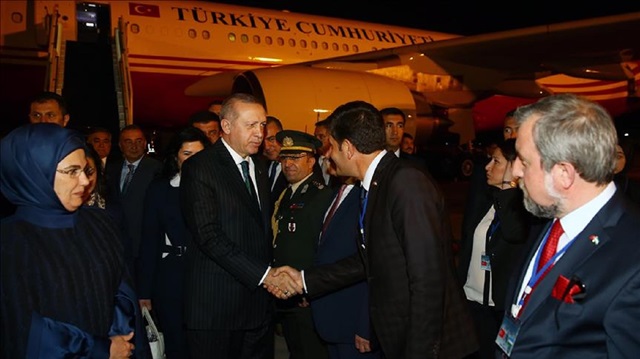 Turkish President Recep Tayyip Erdogan (2nd L) and his wife Emine Erdogan (L) are welcomed at Tashkent International Airport in Tashkent, Uzbekistan on April 29, 2018