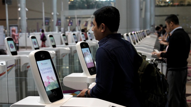 A passenger passes through an automated immigration control gate at Changi airport's Terminal 