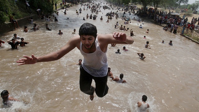 Pakistan'da aşırı sıcaklardan bunalan halk göl ve göletlerde serinlemeye çalışıyor. (Arşiv)