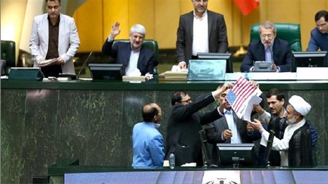 Iranian lawmakers set US flag on fire in parliament
