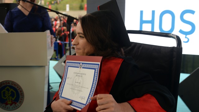 Tıp Fakültesinden birincilikle mezun olan bedensel engelli Sare Aydın'a diplomasını, aynı fakültenin dekanı Prof. Dr. Ertan Bülbüloğlu verdi