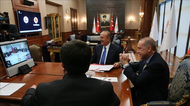 Turkish President Recep Tayyip Erdogan (R) speaks with Venezuelan President Nicolas Maduro via video conference in Ankara, Turkey on May 17, 2018. Turkish Foreign Minister Mevlut Cavusoglu (2nd R) also attended the meeting.