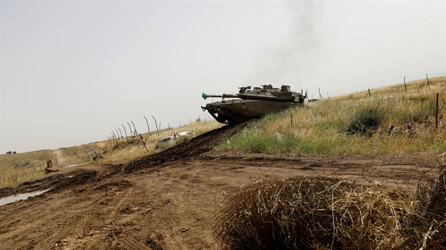 A cow walks past tanks near the border with Syria in the Israeli-occupied Golan Heights